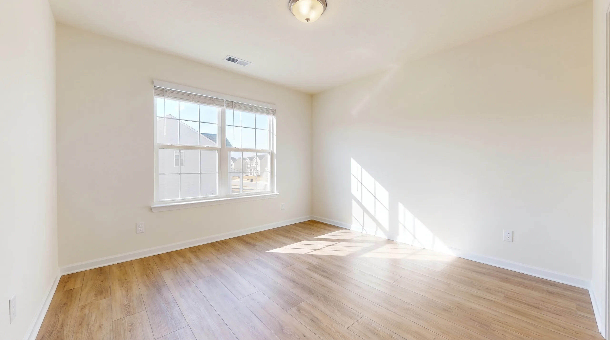 Photorealistic image of a completely empty, spotless standard room in an American suburban home. Freshly painted walls, clean luxury vinyl plank floors, completely ready for new tenants. Bright sunlight, practical clean aesthetic, absolutely no furniture.